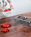 Organizer frigorifero in uso con pomodorini freschi - contenitore trasparente per conservare verdure in cucina moderna