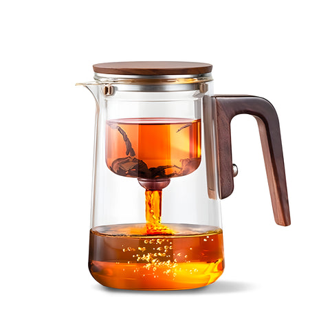Teiera vetro con infusore in azione: tè caldo in infusione, sistema filtro separazione visibile, design elegante trasparente